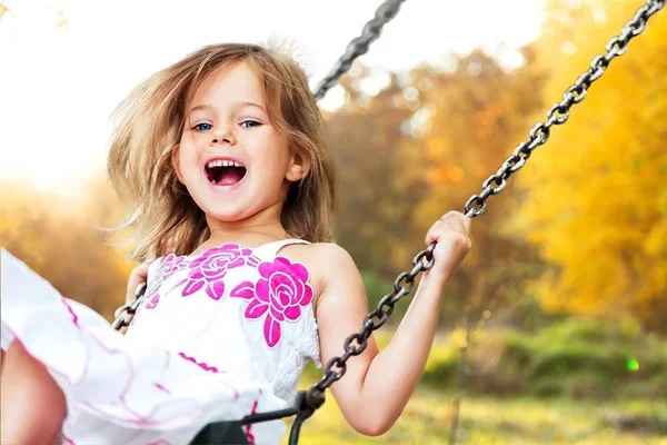 küçük kız salıncakta eğleniyor