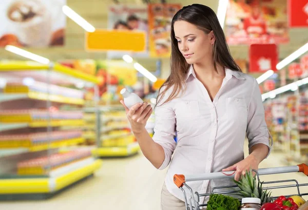 Woman pushing shopping cart — Stock Photo, Image