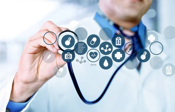 Läkare med stetoskop och digitala ikoner — Stockfoto