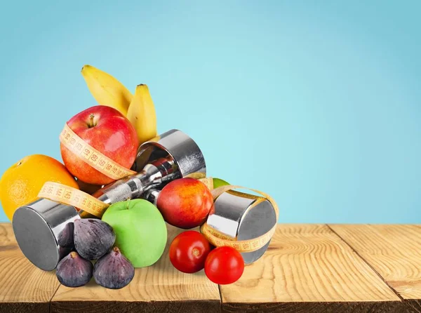 dumbbells with measuring tape and fruits