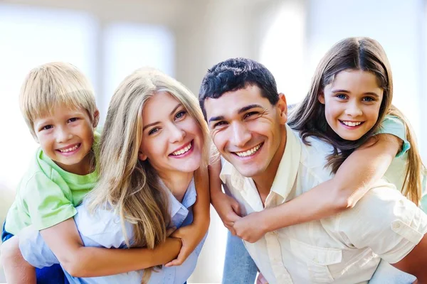 Famiglia sorridente seduta a casa — Foto Stock