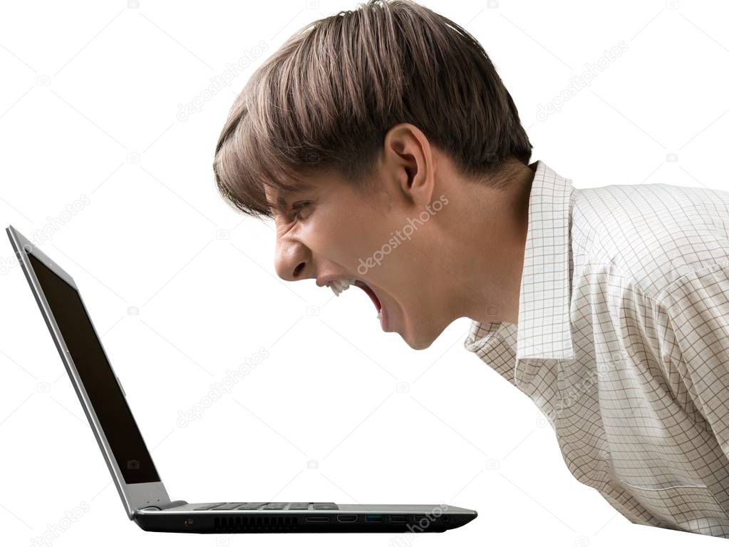 Young man screaming on laptop