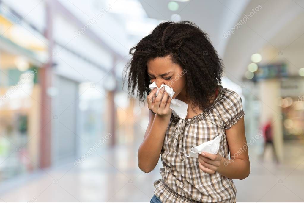  woman sneezing in a tissue 
