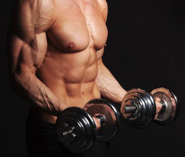 Adam dambıllarla egzersiz yapıyor.