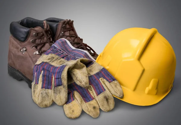 Capacete amarelo com botas — Fotografia de Stock