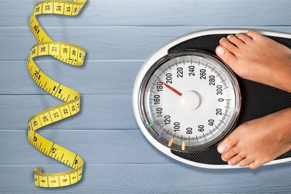 Young woman standing on scales — Stock Photo, Image