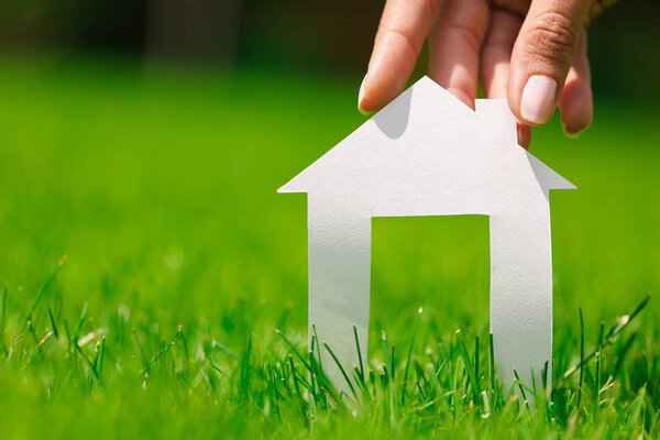 Женщина держит модель домика
