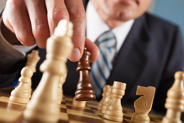 Homem de negócios de terno joga xadrez — Fotografia de Stock