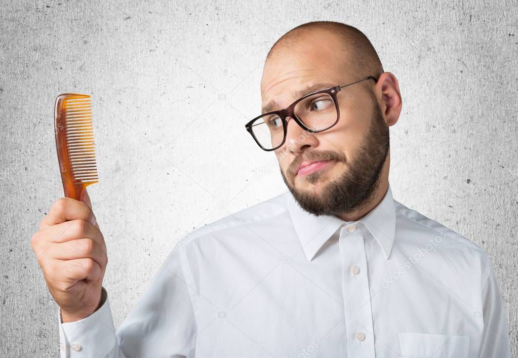 bald  man hand holding comb 