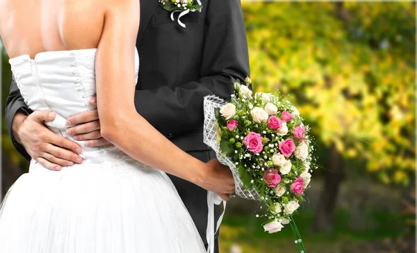 Braut und Bräutigam halten Blumenstrauß — Stockfoto