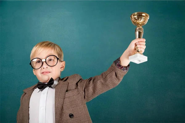 Menino de óculos segurando troféu — Fotografia de Stock