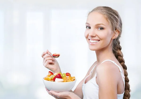 Ung kvinna äta frukter — Stockfoto