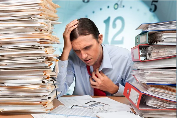 Businessman near heap of papers