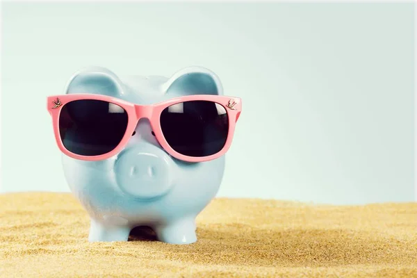 Piggy bank with sunglasses on the beach — Stock Photo, Image