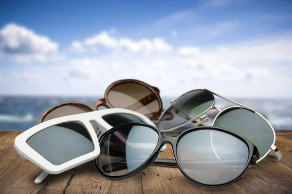 Óculos de sol no fundo da praia — Fotografia de Stock