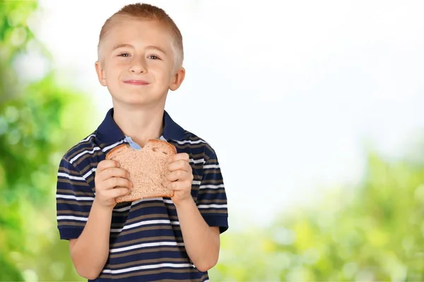 Süßer kleiner Junge mit Brot — Stockfoto