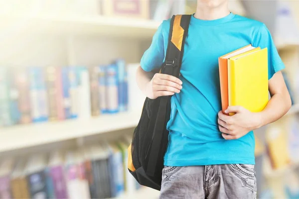 Teen pojke med skolväska och bok — Stockfoto