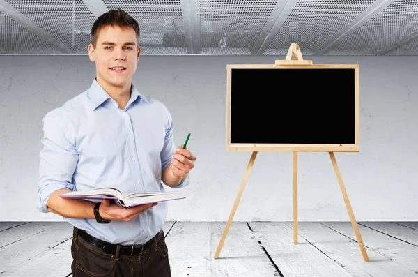 Young male teacher standing with book — Stock Photo, Image