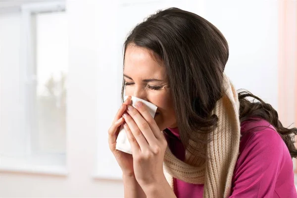 Mujer estornudando en un tejido —  Fotos de Stock