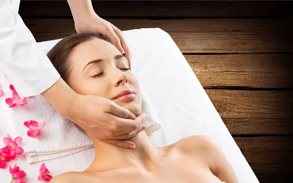 Mujer joven en recibir masaje facial —  Fotos de Stock