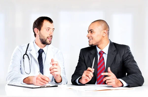 Médico sonriendo con paciente masculino — Foto de Stock