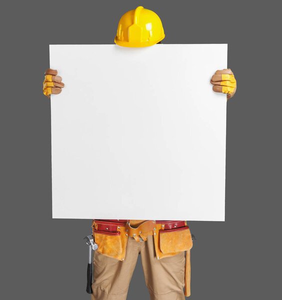 construction worker holding a blank, white sign