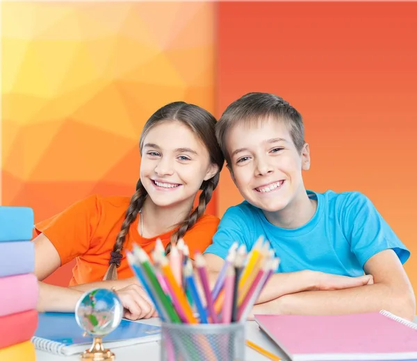 Niños sentados junto a la mesa durante la lección —  Fotos de Stock