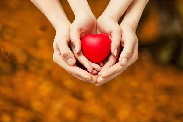 Hombre y mujer sosteniendo el corazón rojo — Foto de Stock