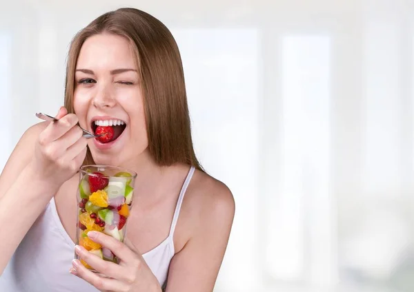 Mujer comiendo ensalada de frutas —  Fotos de Stock