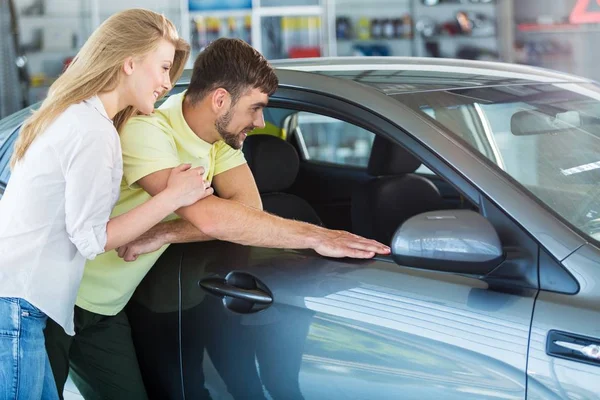 Pareja feliz en salón de auto — Foto de Stock