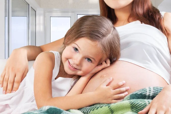 Zwangere vrouw met haar dochter — Stockfoto