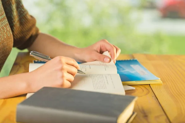 Las manos de la mujer escriben en cuaderno —  Fotos de Stock