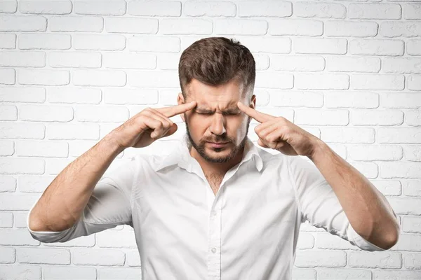 Mann berührt Kopf mit Fingern — Stockfoto