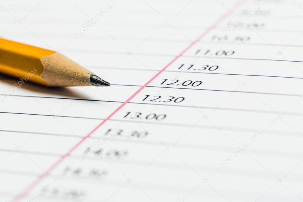 Pencil lying on a calendar showing different time, conceptual of schedules, time management, events, deadlines and organisation