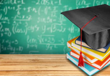 Mezuniyet şapka ve kitap yığını