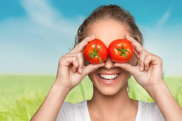 Kobieta oczy krycia z pomidorami — Zdjęcie stockowe
