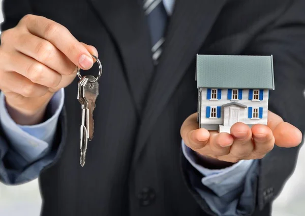 Empresário segurando modelo de casa — Fotografia de Stock