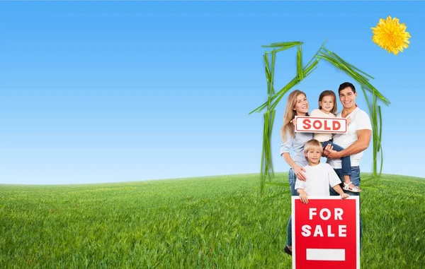 Família feliz com sinal de venda — Fotografia de Stock