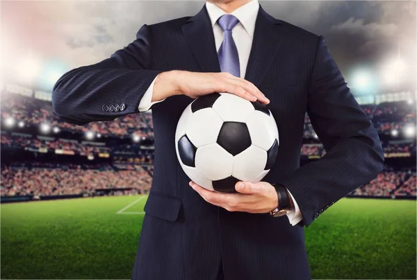 Hombre de negocios sosteniendo pelota de fútbol — Foto de Stock