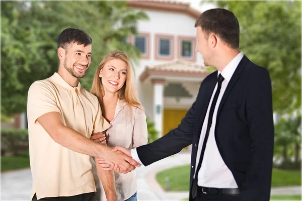 Feliz pareja con el vendedor — Foto de Stock