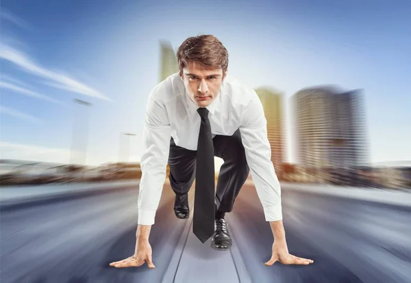 Joven hombre de negocios en la pose de inicio para correr — Foto de Stock