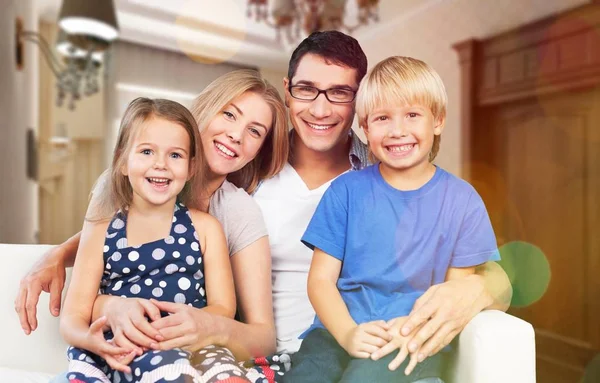 Familia sonriente sentada en casa — Foto de Stock