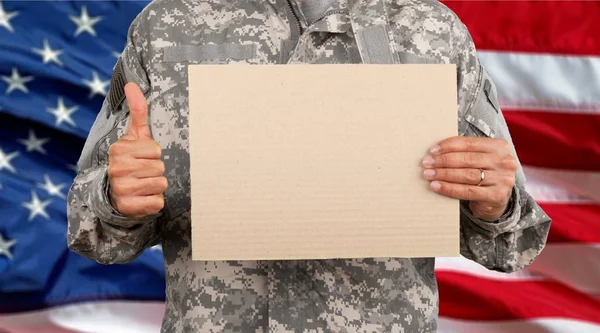 Στρατιώτης Στρατιωτική Στολή Κρατώντας Κενό Χαρτόνι Εναντίον Των Ηπα Σημαία — Φωτογραφία Αρχείου