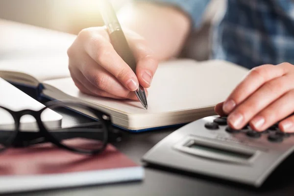 Scrittura a mano dell'uomo d'affari e contare sulla calcolatrice — Foto Stock