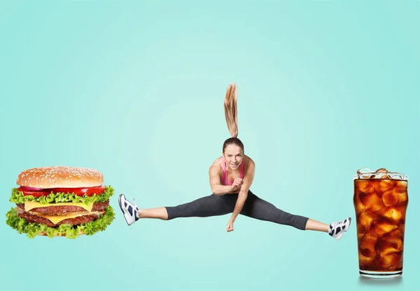 Mujer saltando entre hamburguesa y cola — Foto de Stock