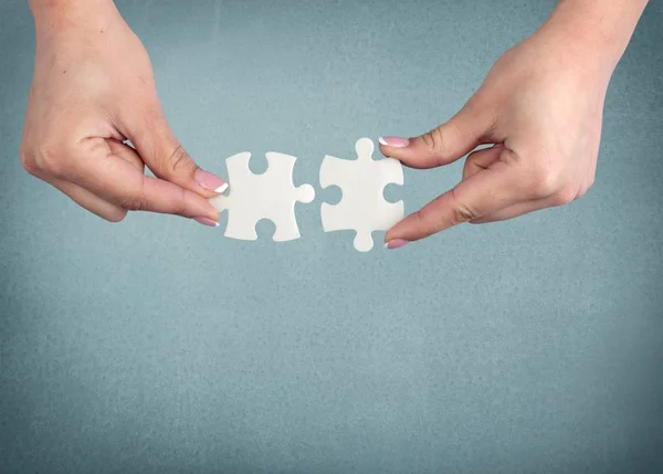 Hands joining puzzle parts — Stock Photo, Image