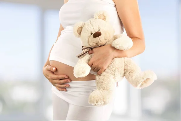 Těhotná žena hospodářství medvěd — Stock fotografie