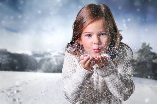 Chica en invierno ropa soplando en la nieve — Foto de Stock