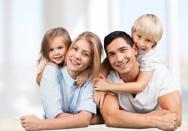 Familia sonriente sentada en casa —  Fotos de Stock