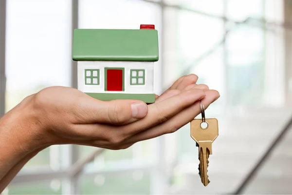 Mujer sosteniendo pequeña casa modelo —  Fotos de Stock